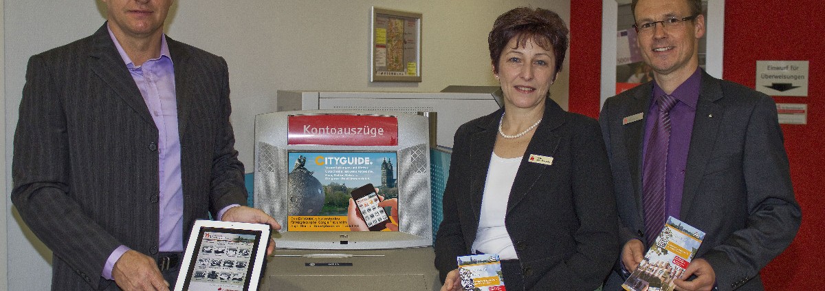 CITYGUIDE goes Stadtsparkasse: Auf allen Kontoauszugdruckern in der Landeshauptstadt wird auf die App aufmerksam gemacht. Ehs-Verlags-Geschäftsführer Raik Wilke konnte die Sparkasse, vertreten durch Beate von Borries und Ulf Holzapfel, als Kooperationspartner gewinnen. Foto: Sabine Lindenau